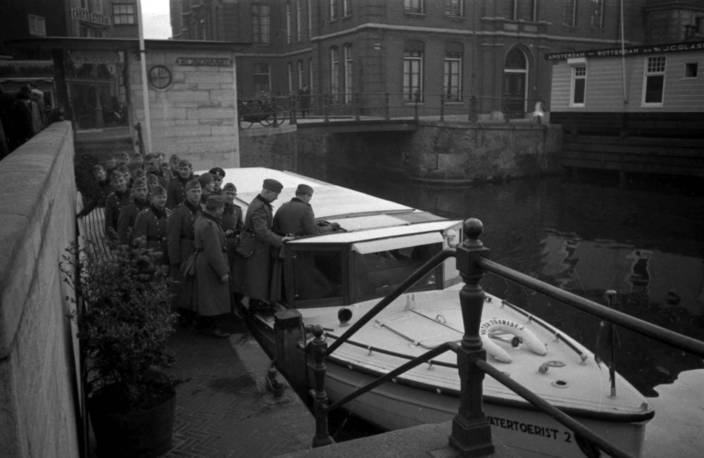 De Ordnungspolizei stapt in bij een rondvaartboot van Rederij Kooy aan het Rokin.