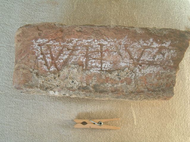 Baksteen met letters.