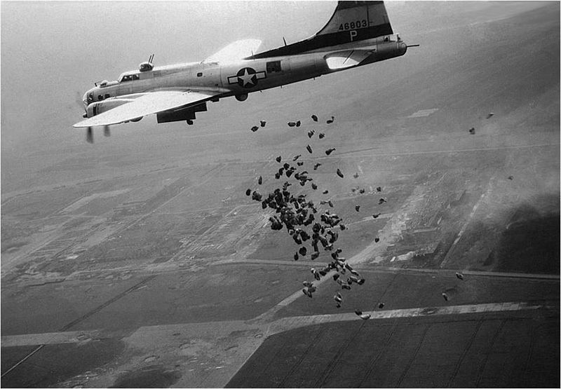 Een Amerikaanse B-17 lost in het kader van operatie Chowhound in mei 1945 boven het totaal verwoeste Schiphol een lading levensmiddelen voor de hongerende Nederlandse bevolking. Beeld: NIMH via Wikimedia Commons.