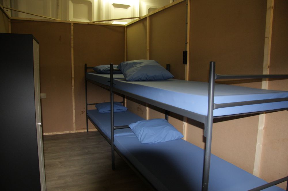 Karig ingerichte slaapkamers met stapelbedden, nauwelijks bergruimte en in het geheel geen privacy. 'Glamping' is het zeker niet.