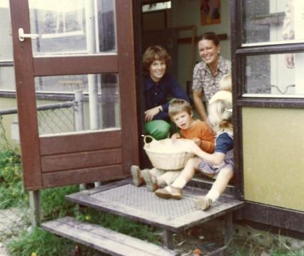 Poseren in de deuropening van het noodlokaal bij de Nicolaas Beetsschool. Om kruipen onder het lokaal tegen te gaan waren er stenen neergelegd.